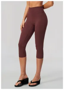 Women's high-waisted burgundy yoga capri leggings with soft brushed texture on a model.