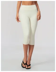 Close-up detail of high-waisted cream yoga capris for women, slim fit athletic workout leggings.