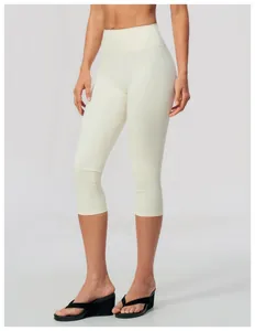 Professional studio shot of cream high-waisted yoga capri leggings on female model