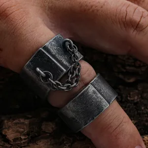 Close-up detail of vintage punk style men's ring with distressed finish and chain link.
