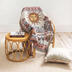 Vue style de vie d'une couverture tissée soleil tarot sur une chaise en rotin clair