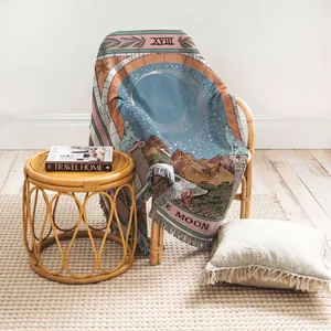 Vue détaillée d'une couverture tissée Tarot de la Lune sur une chaise en rotin.