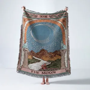 Couverture tissée en coton avec le motif de la carte de Tarot La Lune tenue par quelqu'un