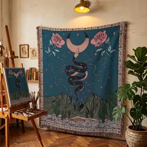 Woven bohemian tapestry with moon and snake design hanging in an artist studio setting