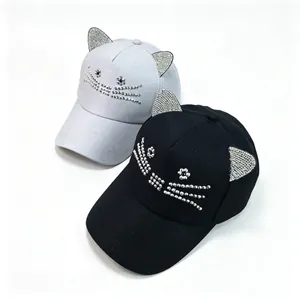 Detailaufnahme der funkelnden Strass-Katzenohren und des Gesichtsdesigns auf Baseballkappen