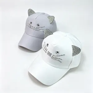 Detailansicht weißer und grauer Baseballkappen mit Strass-Katzenohren auf weiß