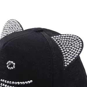 Detaillierte Nahaufnahme der schwarzen Baseballkappe mit Strass-Katzenohren-Deko