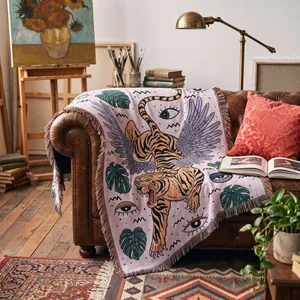 Couverture tissée artistique avec tigre ailé et motif de feuilles tropicales en studio