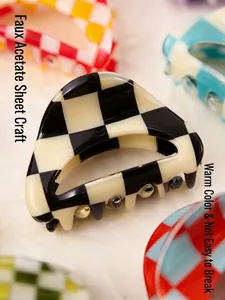 Close-up of a stylish checkerboard pattern hair claw clip made from imitation acetate.