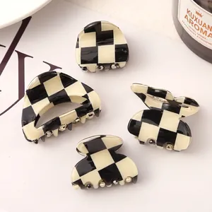 Detail view of stylish checkerboard pattern acetate hair claw clips in various shapes