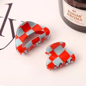 Detailed close-up showing red and blue checkerboard hair claw clips in two sizes