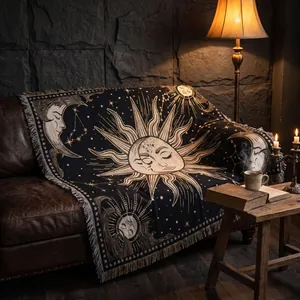 Primo piano di una coperta tessuta bohémien con sole e luna su un divano in pelle vintage.