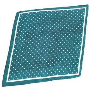 Vue détaillée d'un foulard carré en satin plissé bleu canard avec des pois blancs sur fond blanc.