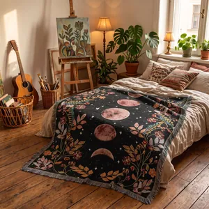 Bohemian moon phase woven throw blanket with floral patterns on a cozy rustic bed setting.