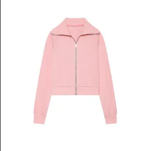 Détail d'une veste en polaire rose zippée avec col à revers et poignets