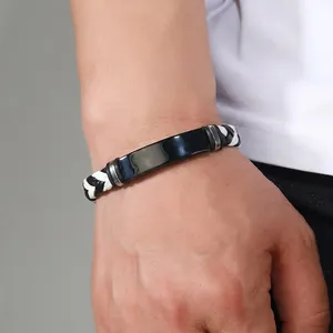 Primer plano de una pulsera masculina de acero inoxidable negro con correa de cuero PU trenzado.