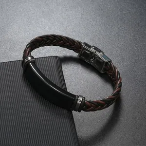 Detalle de una pulsera de cuero trenzado para hombre con placa de acero grabable