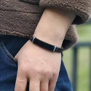 Primer plano de pulsera trenzada de cuero PU con placa de acero inoxidable negra en muñeca