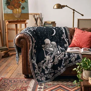 Detailed view of bohemian skeleton lovers woven tapestry blanket draped on a leather sofa