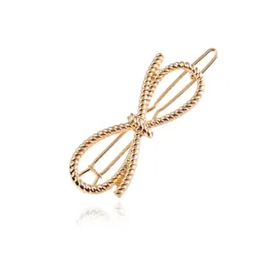 Close-up of a gold-tone hair clip featuring a twisted rope texture and bow-knot shape.