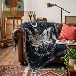 Close-up of bohemian woven tapestry blanket featuring gothic moth and moon phases design