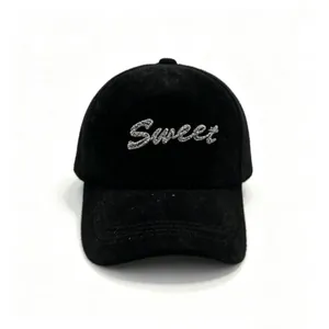 Close-up of a black plush baseball cap with silver glitter 'Sweet' lettering decoration.