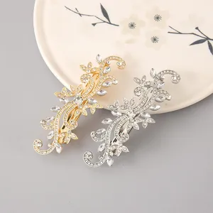 Detailed view of ornate gold and silver floral hair clips with sparkling rhinestones