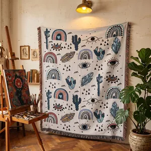 Bohemian woven throw blanket with mystical patterns displayed in an artistic studio setting
