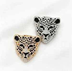 Gros plan de broches tête de léopard incrustées de strass en finitions or et argent