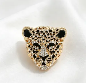 Gros plan d'une broche léopard dorée vintage avec strass étincelants et détails en émail noir.