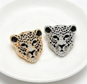 Gros plan sur d'élégantes broches tête de léopard vintage avec strass brillants en or et argent
