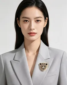 Détail d'une broche tête de léopard vintage avec strass portée sur un blazer gris