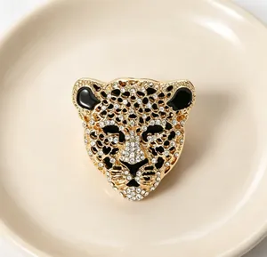 Gros plan d'une broche tête de léopard étincelante en métal doré sertie de strass