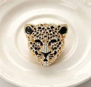 Vue détaillée d'une broche léopard en or avec des strass étincelants et de l'émail noir.