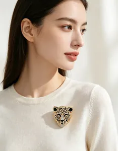Vue détaillée d'une broche léopard vintage en strass sur un pull en maille blanc