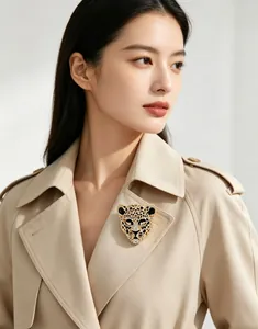Vue détaillée d'une broche tête de léopard vintage avec strass sur un trench-coat beige.