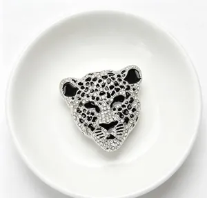 Gros plan détaillé d'une broche tête de léopard étincelante avec strass et émail noir