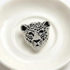 Broche tête de léopard vintage avec strass étincelants sur une assiette en porcelaine blanche