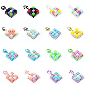 Lot de porte-clés fidget à 9 touches mécaniques décliné en plusieurs tons macaron.