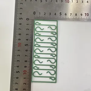 Vue détaillée des crochets de Noël en plastique vert avec règle pour référence