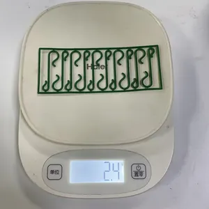Détail montrant les crochets de décoration de Noël légers de 2,4g sur une balance