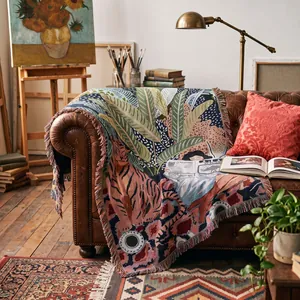 Bohemian woven multi-functional throw blanket featuring tiger and leaf art on a sofa