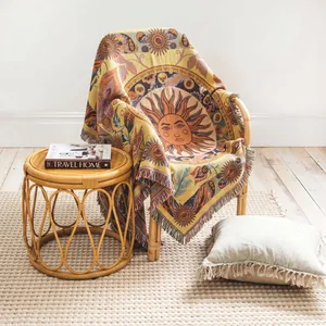 Dettaglio di una coperta tessuta in stile boho con motivo solare su una sedia in rattan