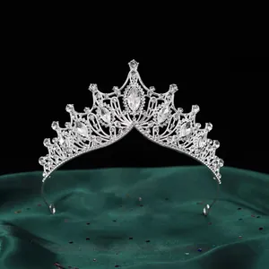 Detaillierte Ansicht einer silbernen Barock-Tiara mit Kristallen auf grünem Seidenstoff