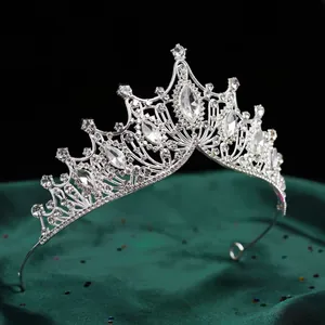 Detailansicht einer luxuriösen Brautkrone in Silber mit Kristallen auf grüner Seide