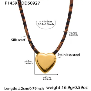 Detailed view of stainless steel heart necklace with leopard silk scarf band.