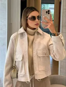 Detailweergave van het stijlvolle beige jasje met rits en grote borstzakken op de borst
