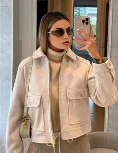 Detail view of stylish beige soft-textured jacket with zipper and large chest pockets
