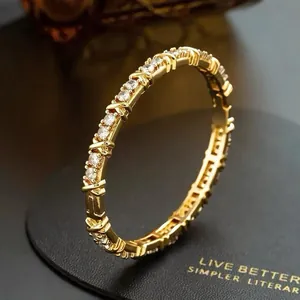 Detailed macro view of a gold-plated bangle set with sparkling cubic zirconia stones