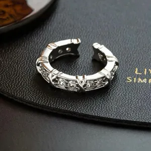 Close-up of silver-plated ring featuring CZ stones and crossing X motifs